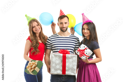 Young people in birthday party caps with gift boxes on white background