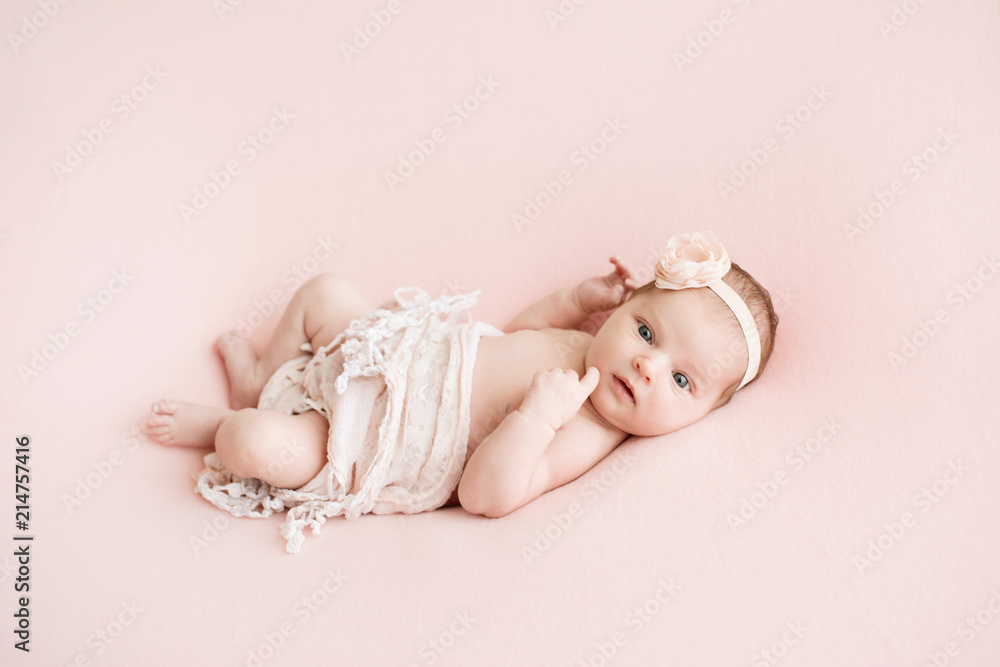 Newborn girl on a pink background. Photoshoot for the newborn. 7 days