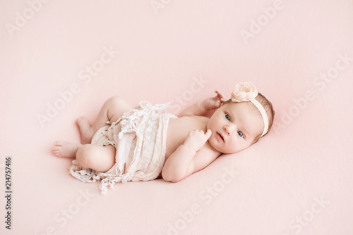 Newborn girl on a pink background. Photoshoot for the newborn. 7 days from birth. A portrait of a beautiful, seven day old, newborn baby girl
