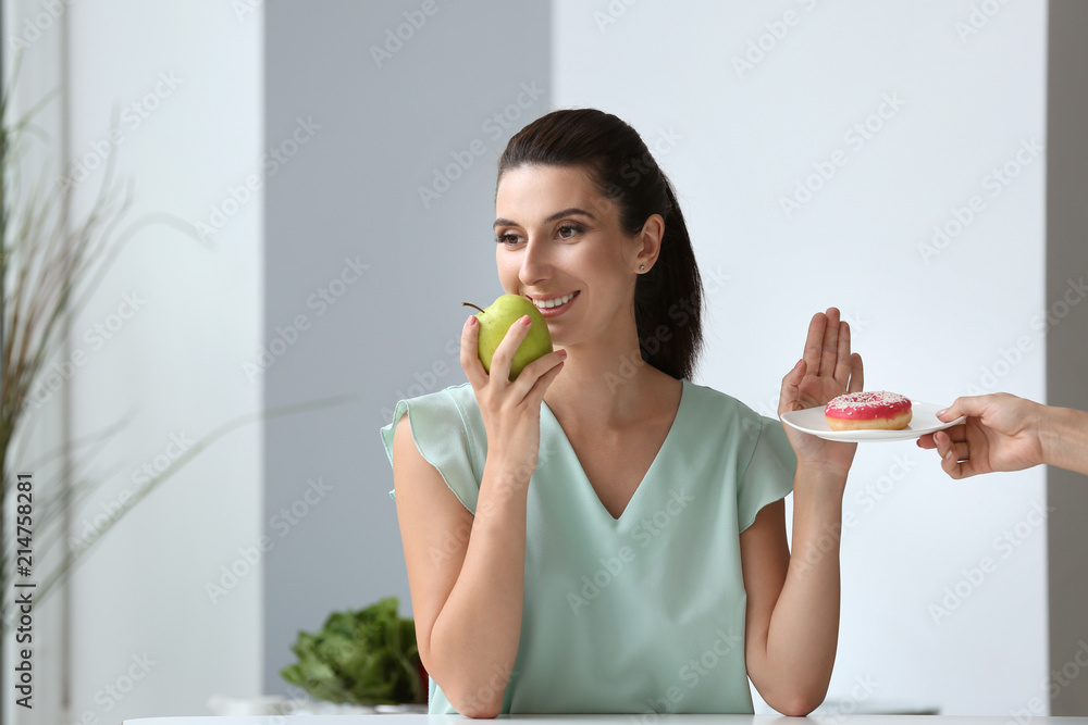 Woman refusing to eat unhealthy food indoors. Diet concept Woman refusing to eat unhealthy food indoors. Diet concept