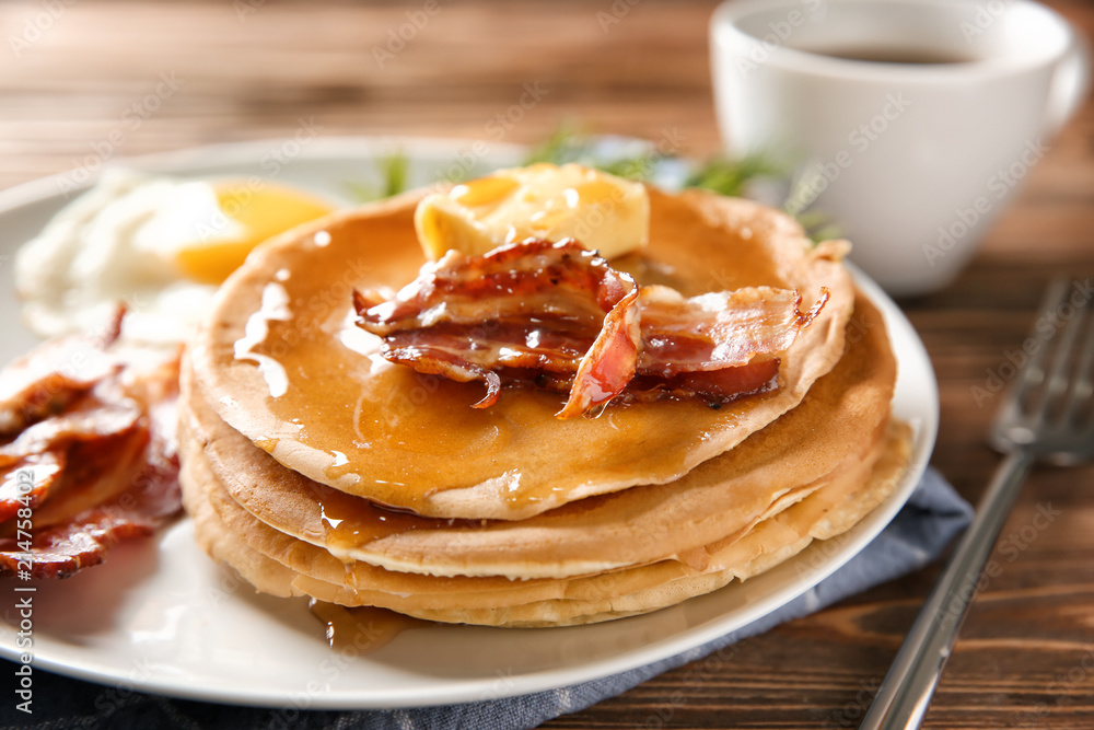 Plate with tasty pancakes and bacon on wooden table, closeup Plate with tasty pancakes and bacon on wooden table, closeup
