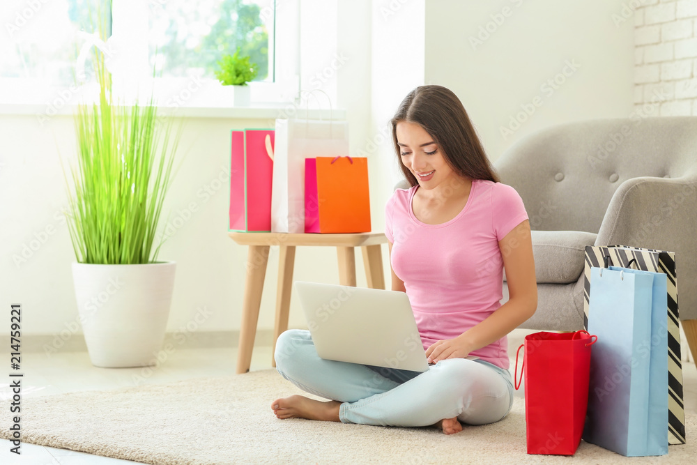 Young woman shopping online with laptop at home Young woman shopping online with laptop at home