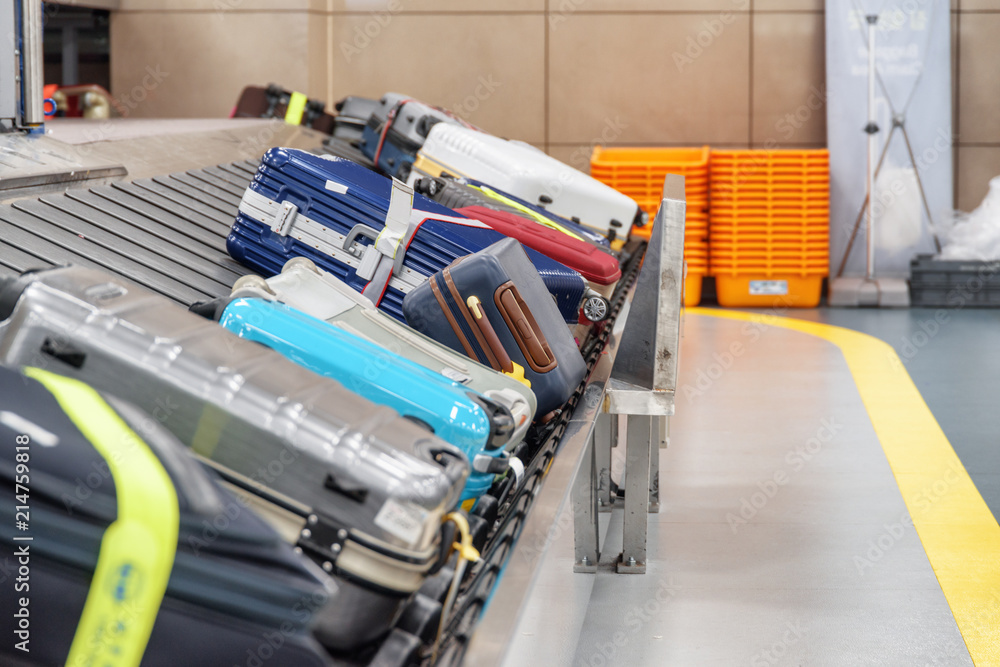 Fototapeta premium Suitcases on luggage conveyor belt in airport. Baggage carousel