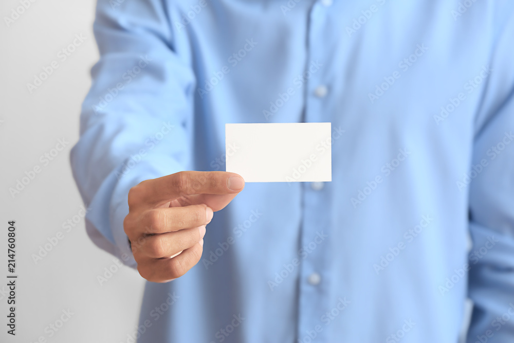 Man with business card on light background, closeup Man with business card on light background, closeup