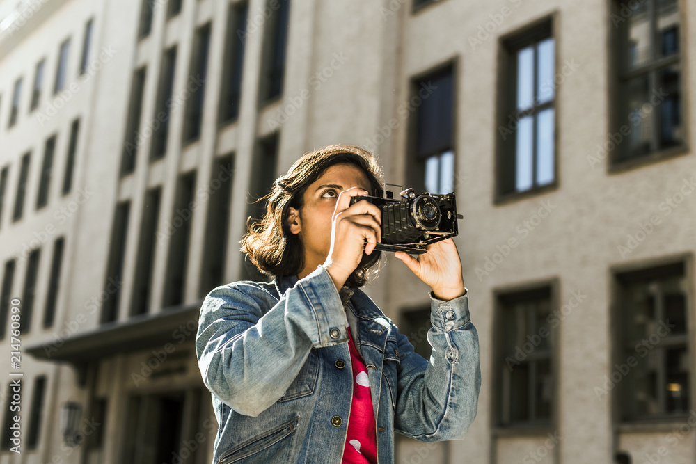 Woman with retro camera in the city