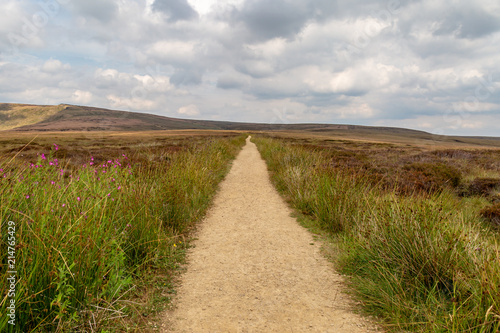 Looking down an empty pathway along the Pennine Way in Derbyshire  with a cloudy sky overhead