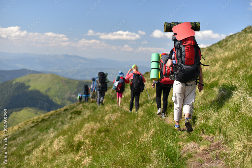 group hikers walking by mountains path