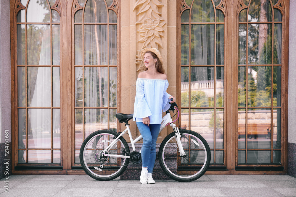 Fototapeta premium Beautiful young woman with bicycle outdoors