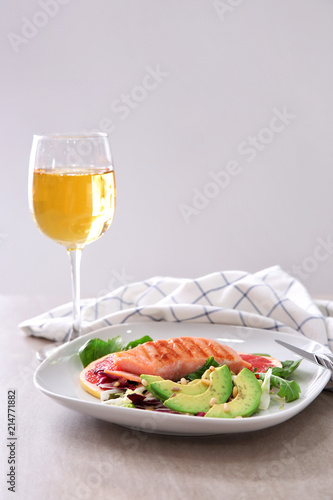 Plate with tasty grilled fish and vegetables on table