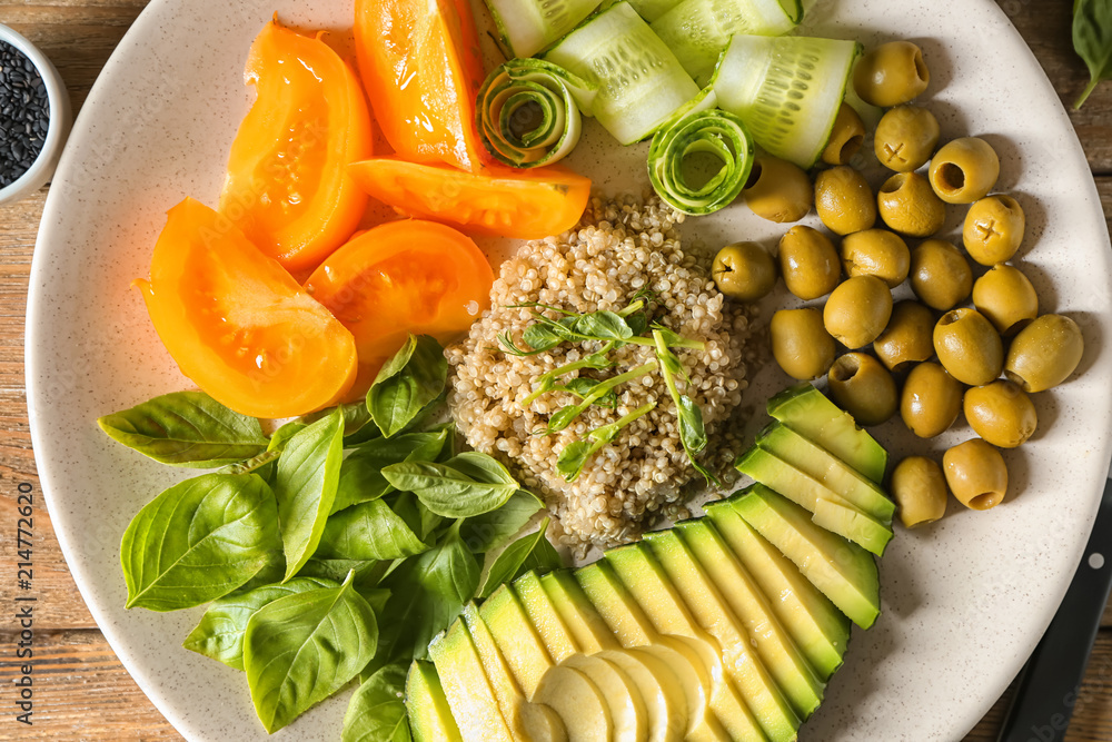 Plate with delicious healthy fresh salad on wooden table, closeup