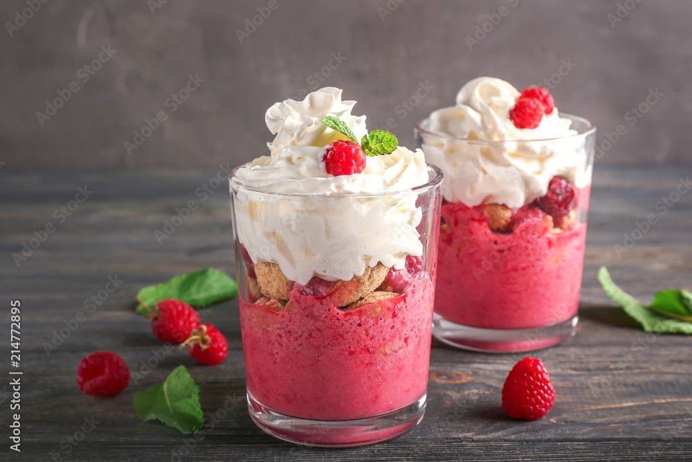Glasses with tasty raspberry dessert on wooden table Glasses with tasty raspberry dessert on wooden table