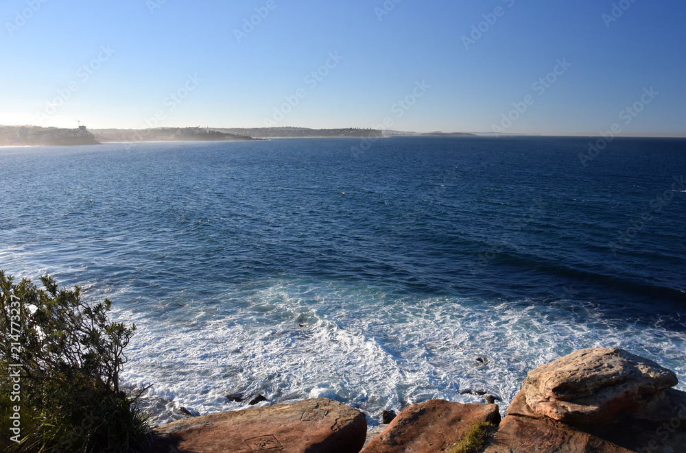 Fog creeping at Northern beaches on a sunny afternoon in winter time. View from Cabbage Tree Reserve lookout.