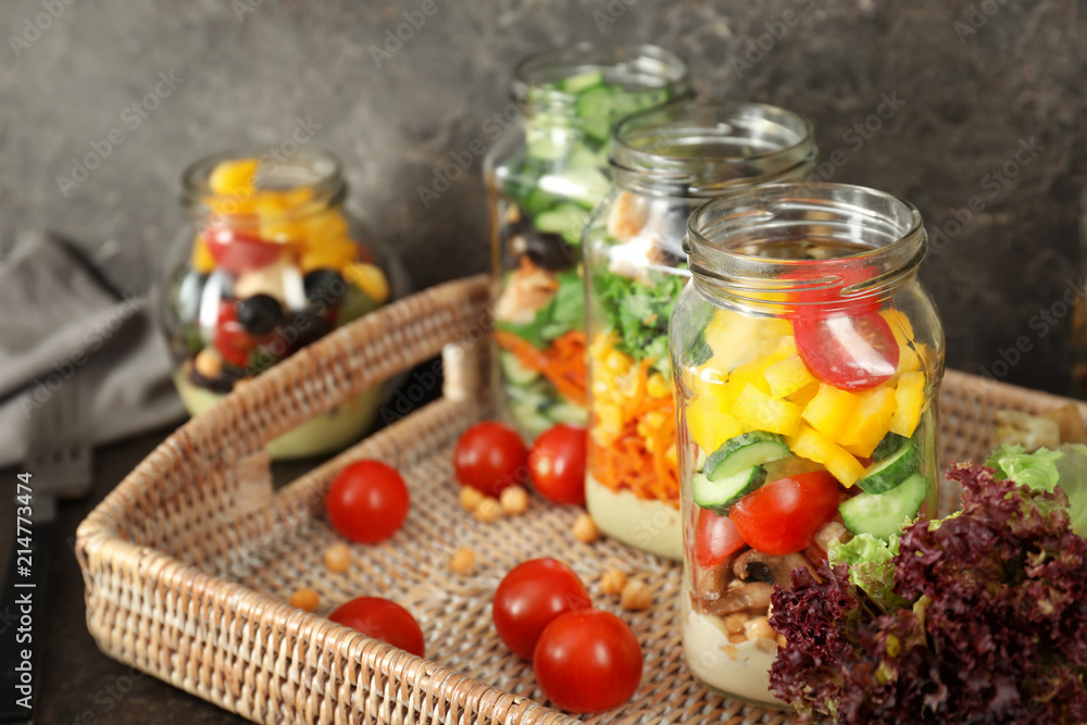 Delicious vegetable salads in mason jars on wicker tray Delicious vegetable salads in mason jars on wicker tray