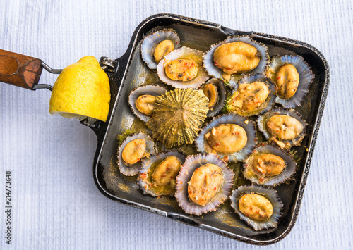 Foto Grilled limpets in the pan served with lemon