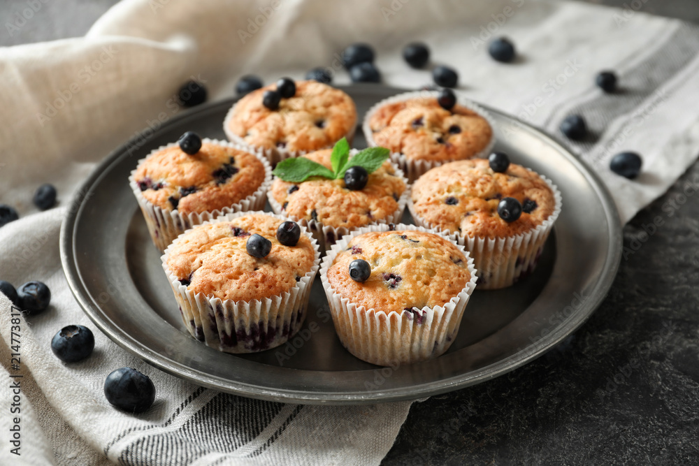 Plate with tasty blueberry muffins on table Plate with tasty blueberry muffins on table