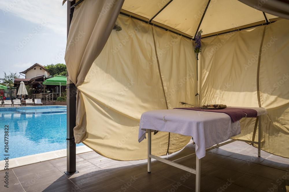 a separate massage area next to a mineral water pool. Body and soul care, rest and spa treatments. bed for massages in the tent and beautiful flowers for an unforgettable holiday.