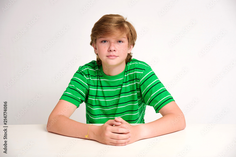 portrait of a cute teenager on a white background at the table portrait of a cute teenager on a white background at the table