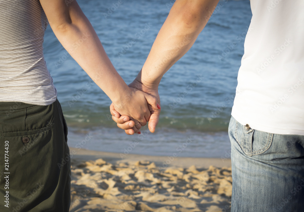 Man and woman holding hands against the sea Man and woman holding hands against the sea
