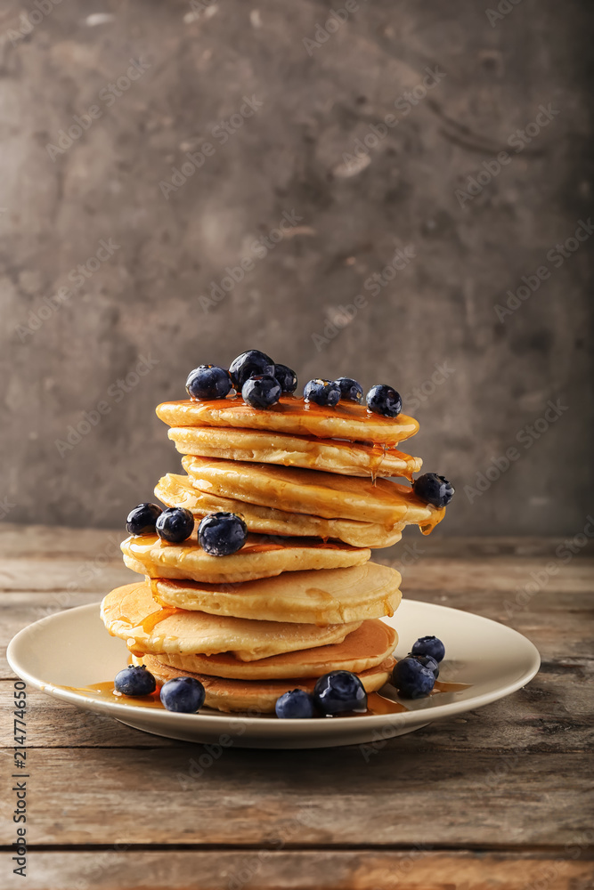 Plate with delicious pancakes and berries on wooden table Plate with delicious pancakes and berries on wooden table