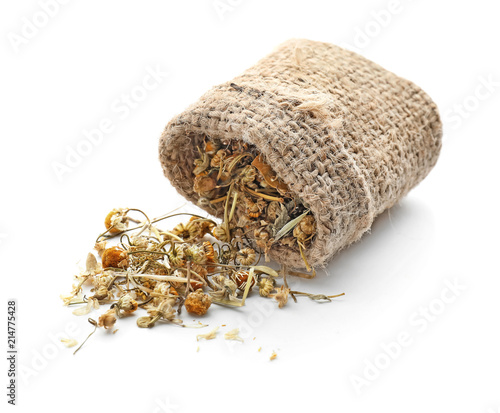 Sack with dried chamomile flowers on white background