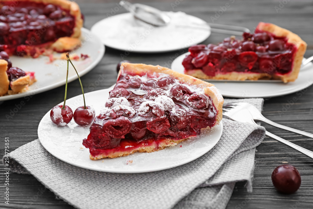 Plate with piece of tasty homemade cherry pie on wooden table Plate with piece of tasty homemade cherry pie on wooden table