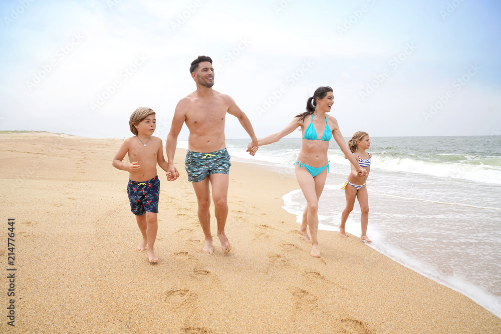 Cheerful family running on sandy beach Cheerful family running on sandy beach