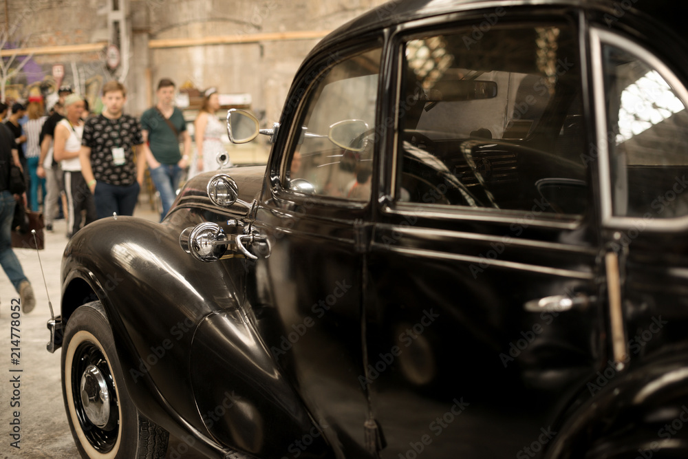 Fragmeyn of a retro black car  with close top at an exhibition 'Pin up' in the old premises of an abandoned factory   in Kharkov, Ukraine, 05.19..2018