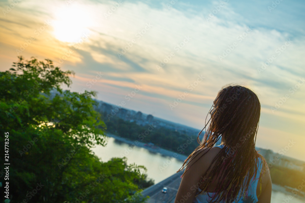 Rear view of teenage girl looking to the sun / Urban sunset scene. Millennial Generation