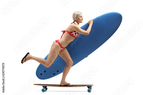 Young woman with a surfboard riding a longboard