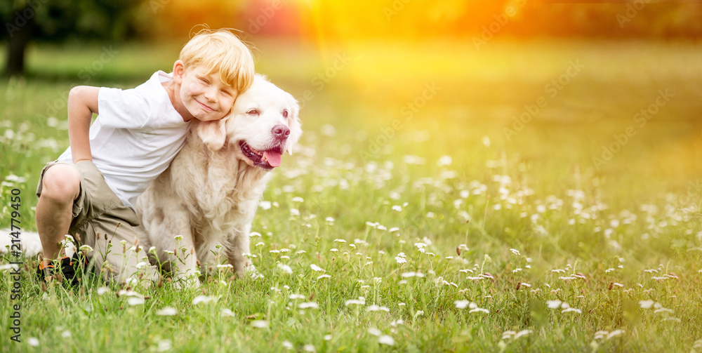 Fototapeta premium Junge geht mit Golden Retriever Hund Gassi im Park