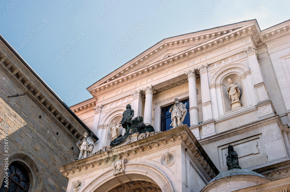 Facade of the Cathedral of Bergamo, Italy on a sunny day. The facade is decorated with sculptures