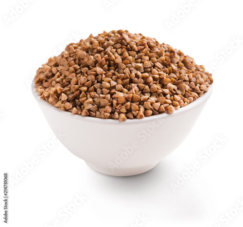 Dry buckwheat in ceramic bowl isolated on white