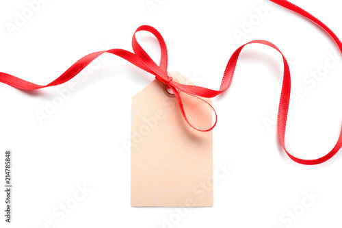 Blank gift tag with red ribbon on white background