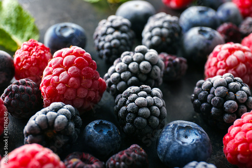 Delicious frozen berries on grey background, closeup