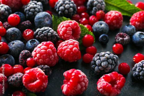 Delicious frozen berries on grey background