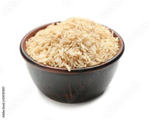 Bowl with brown rice on white background