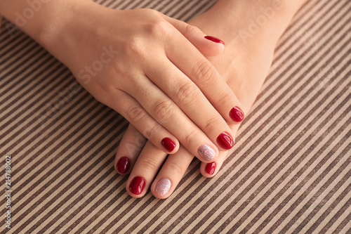 Female hands with stylish color nails on paper, closeup