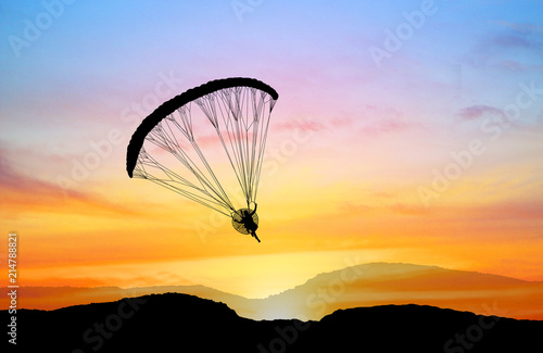 silhouette Para-motor flying on the sky at sunset