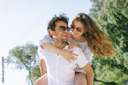 low angle view of smiling boyfriend giving piggyback to girlfriend outdoors © LIGHTFIELD STUDIOS