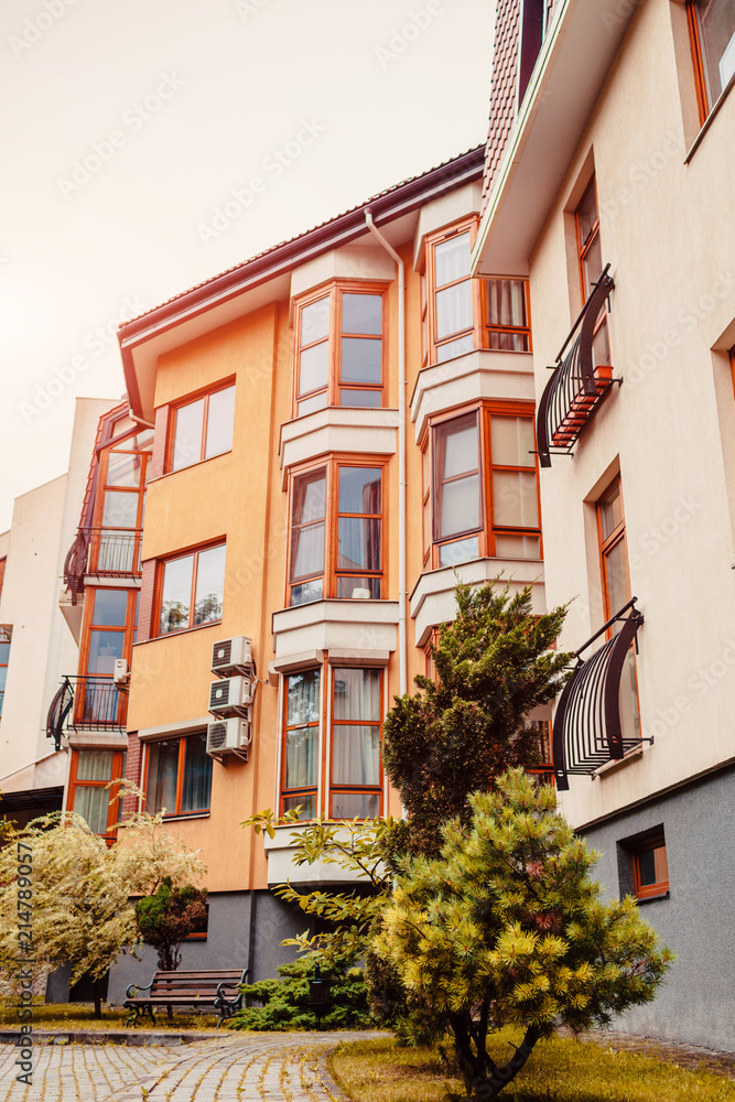 Fototapeta premium New multi-storey residential building. Modern house dyed in red and orange colors
