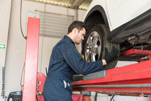 Auto Mechanic Adjusting Car Tire In Repair Shop