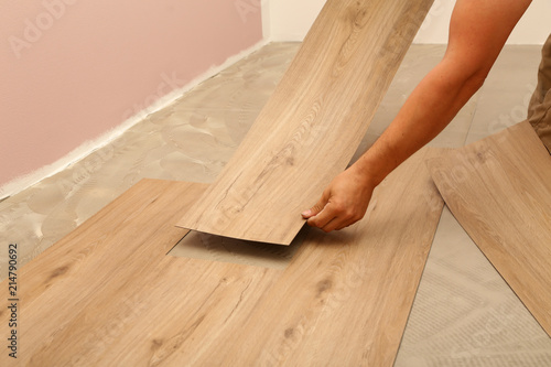 worker installing new vinyl tile floor