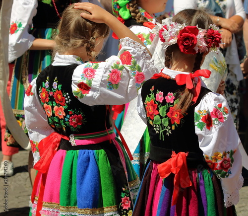Stockfoto Dziewczynki ubrane w tradycyjne ludowe stroje łowickie podczas  corocznej procesji Bożego Ciała w Łowiczu, Polska, w tle tłum uczestników  procesji | Adobe Stock