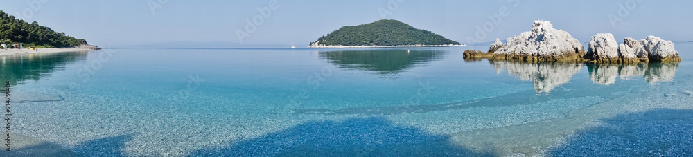 Sea rocks at calm and crystal clear turquoise water at morning, Milia beach, island of Skopelos, Greece