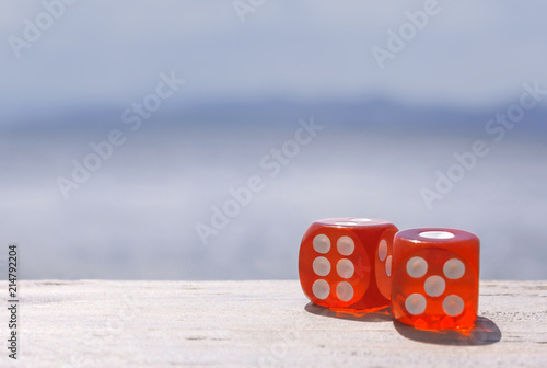 Two red dice on wooden table on nature background. concept for business risk, chance, good luck or gambling. Copy space photo