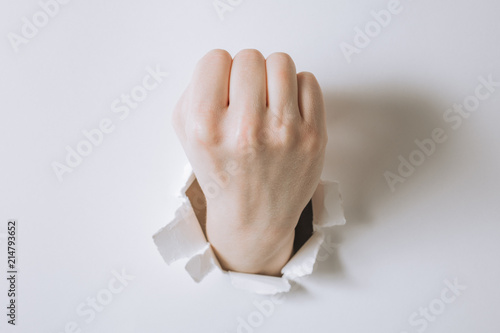 girl hand breaks white paper and shows a gesture