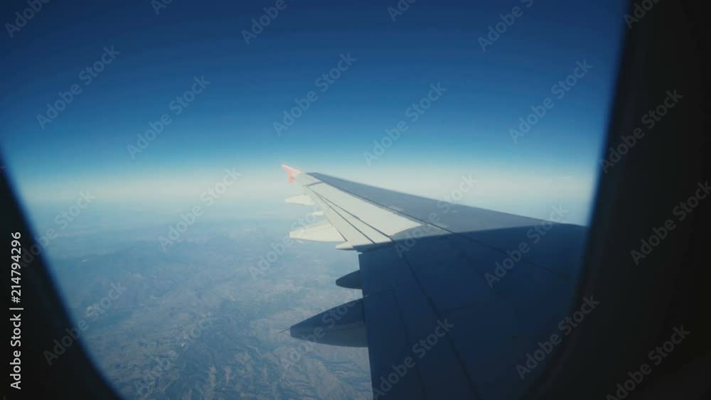 View through the airplane's window, wing, clouds, blue sky nature View through the airplane's window, wing, clouds, blue sky nature
