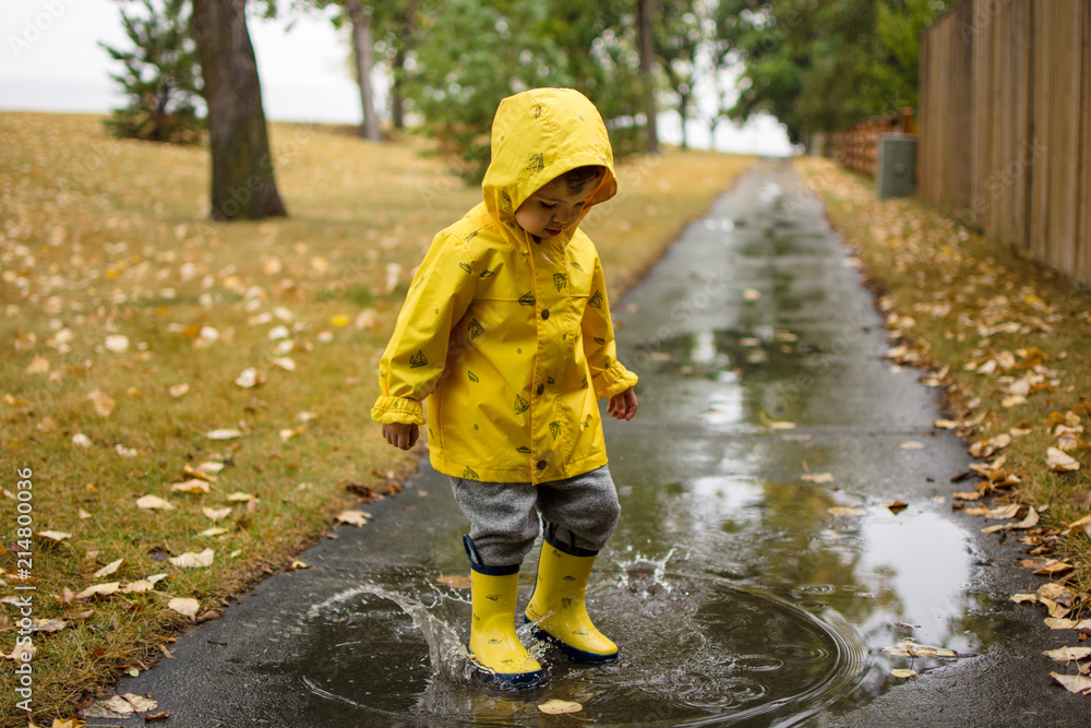Happy toddler jumping in a puddle Happy toddler jumping in a puddle