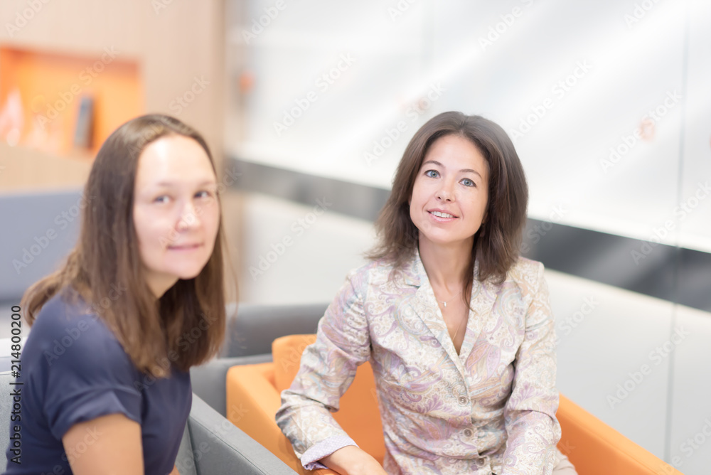 Image of two female co-workers having a discussion on a project. Image of two female co-workers having a discussion on a project.