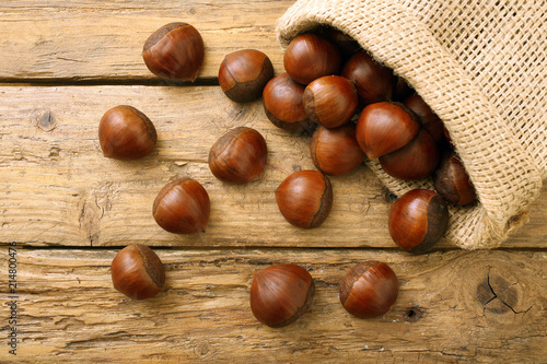 marroni o castagne crude su tavolo di legno rustico